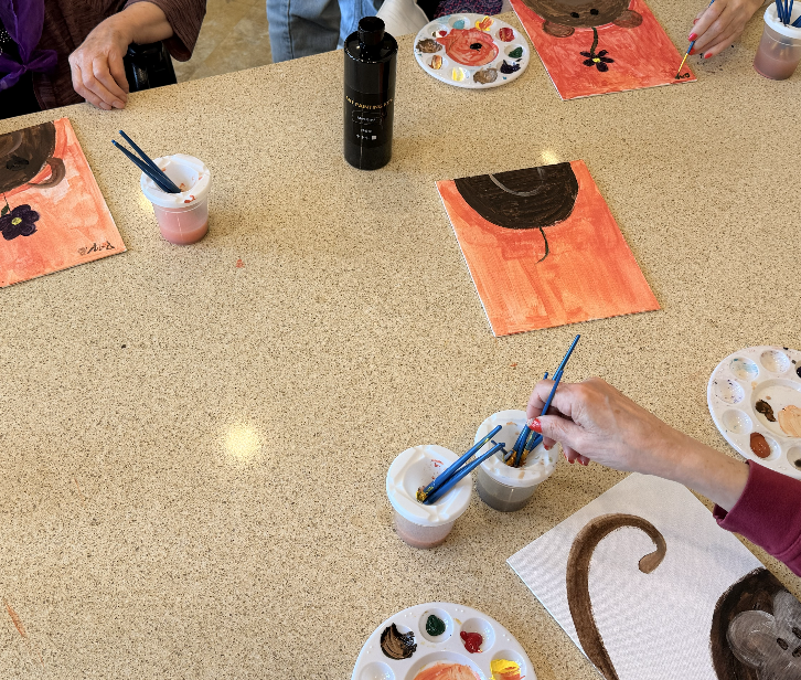 Workshop table with several animal-themed paintings in progress.